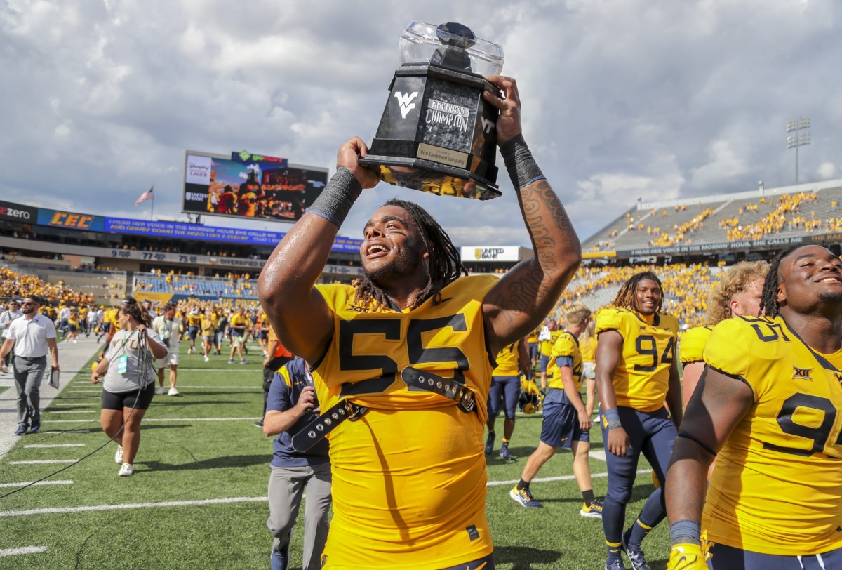 Sep 18, 2021; Morgantown, West Virginia, USA; West Virginia Mountaineers defensive lineman Dante Stills (55) celebrates with the Black Diamond Trophy after defeating the Virginia Tech Hokies at Mountaineer Field at Milan Puskar Stadium.